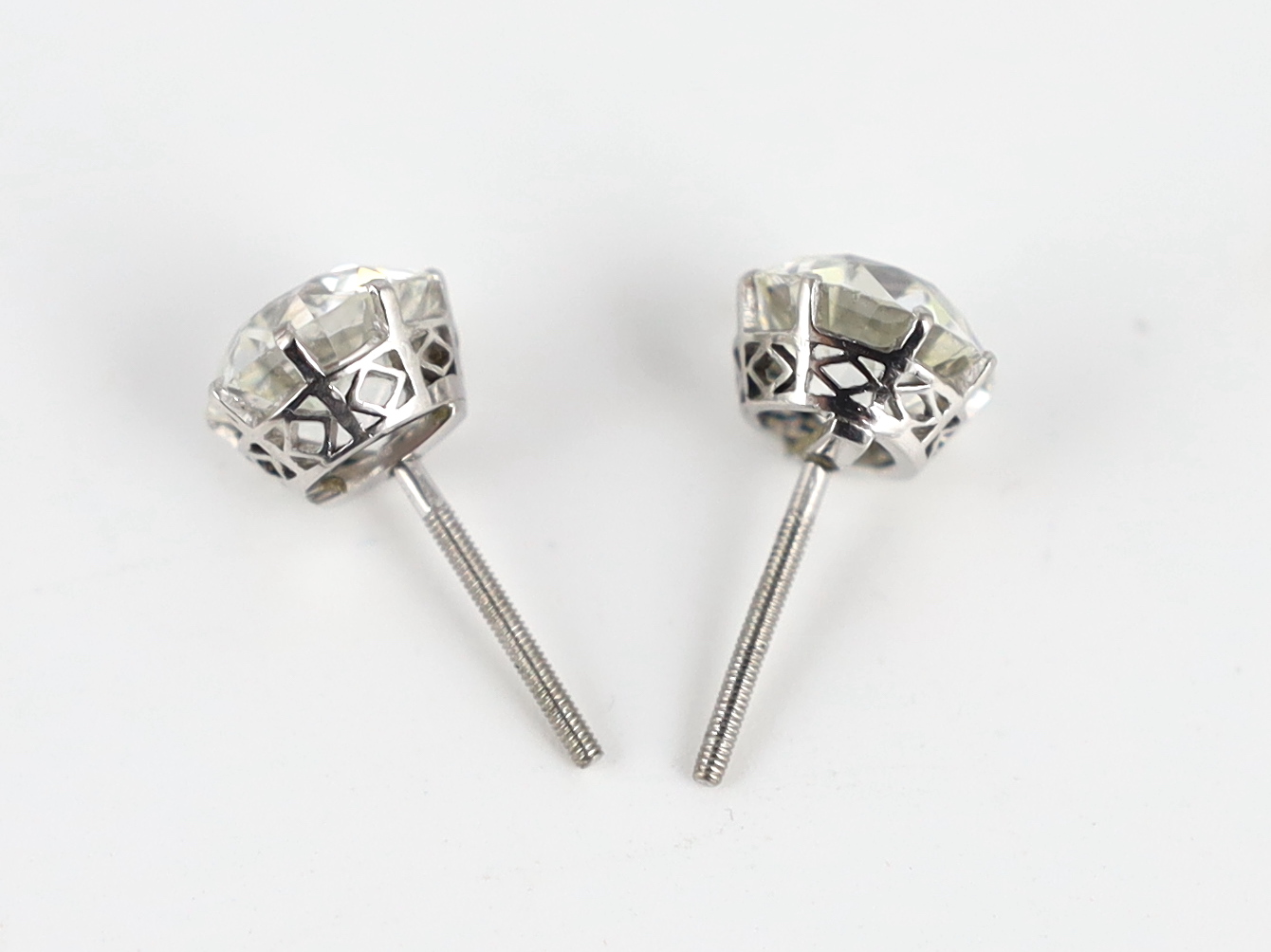 A pair of early 20th century platinum and claw set diamond ear studs